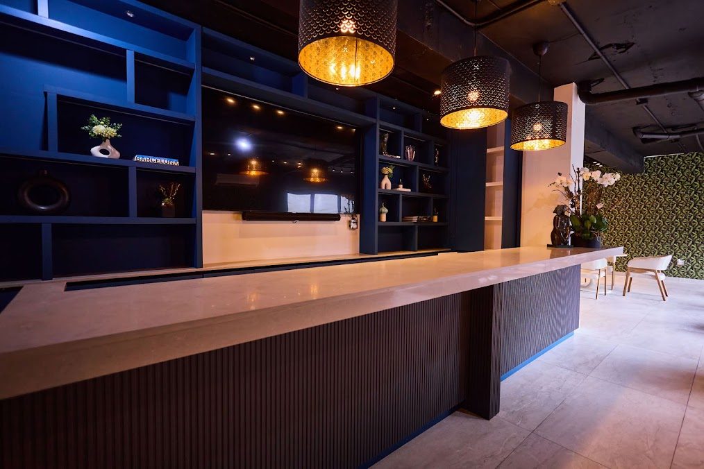Reception counter at Ola Boutique Hotel with blue shelving behind it